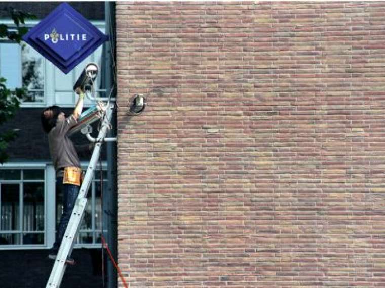 Jill Magid, Rhinestoning Headquarters. System Azure Public performance and permanent installation. Rhinestone encrusted surveillance cameras, posters. Police Headquarters, Amsterdam. 2002