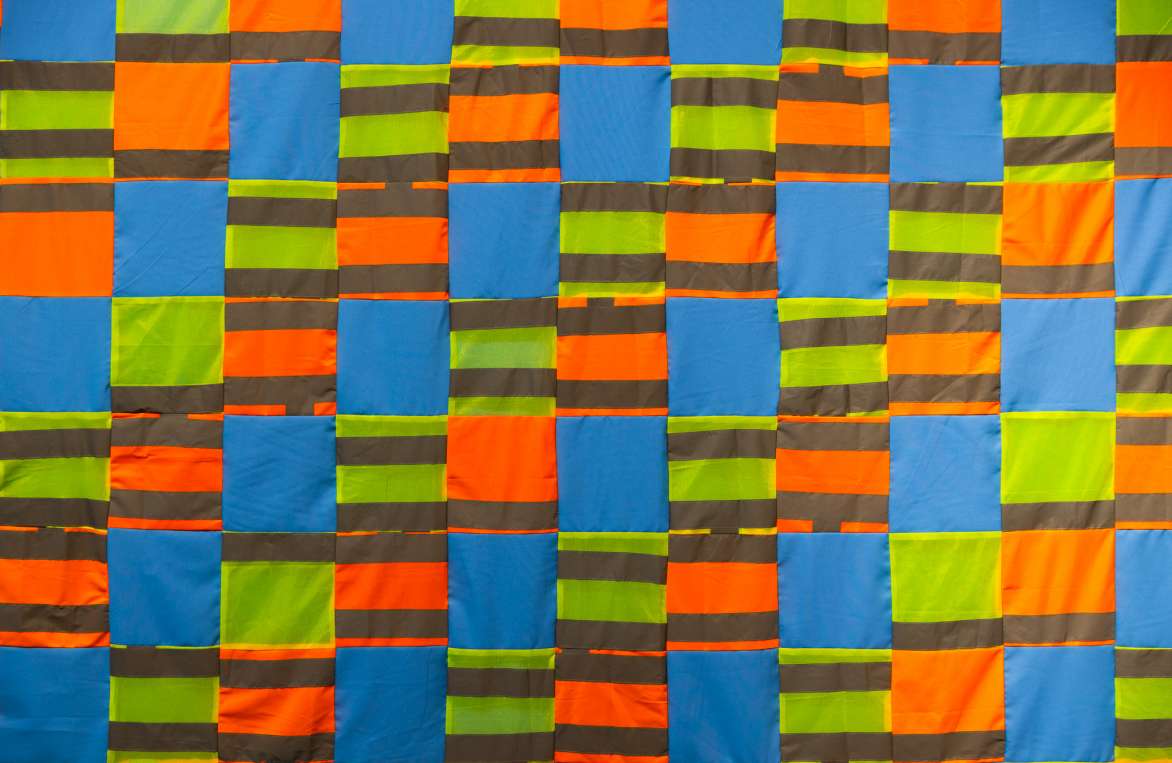 Christopher Joshua Benton, The People Who Build this City, 2021. Construction worker safety vests, fabric. 118h x 39w in