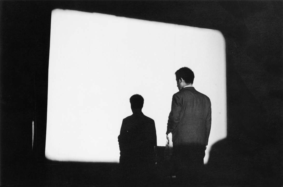 Peter Moore, Paik standing in front of Zen for Film, 1964. © Nam June Paik Estate. Photo: Peter Moore; Peter Moore Photography Archive, Charles Deering McCormick Library of Special Collections, Northwestern University Libraries. © Northwestern University.